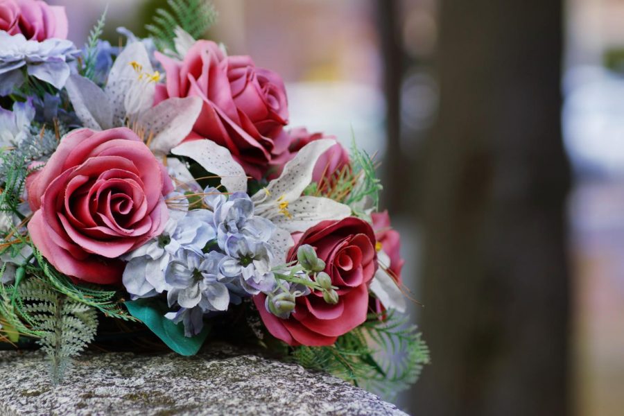 a bouquet of flowers resting on top of a tombstone