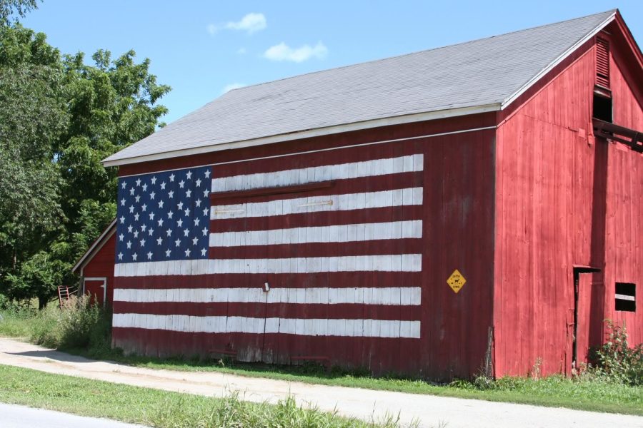 American flag painted on the side of a red barn.